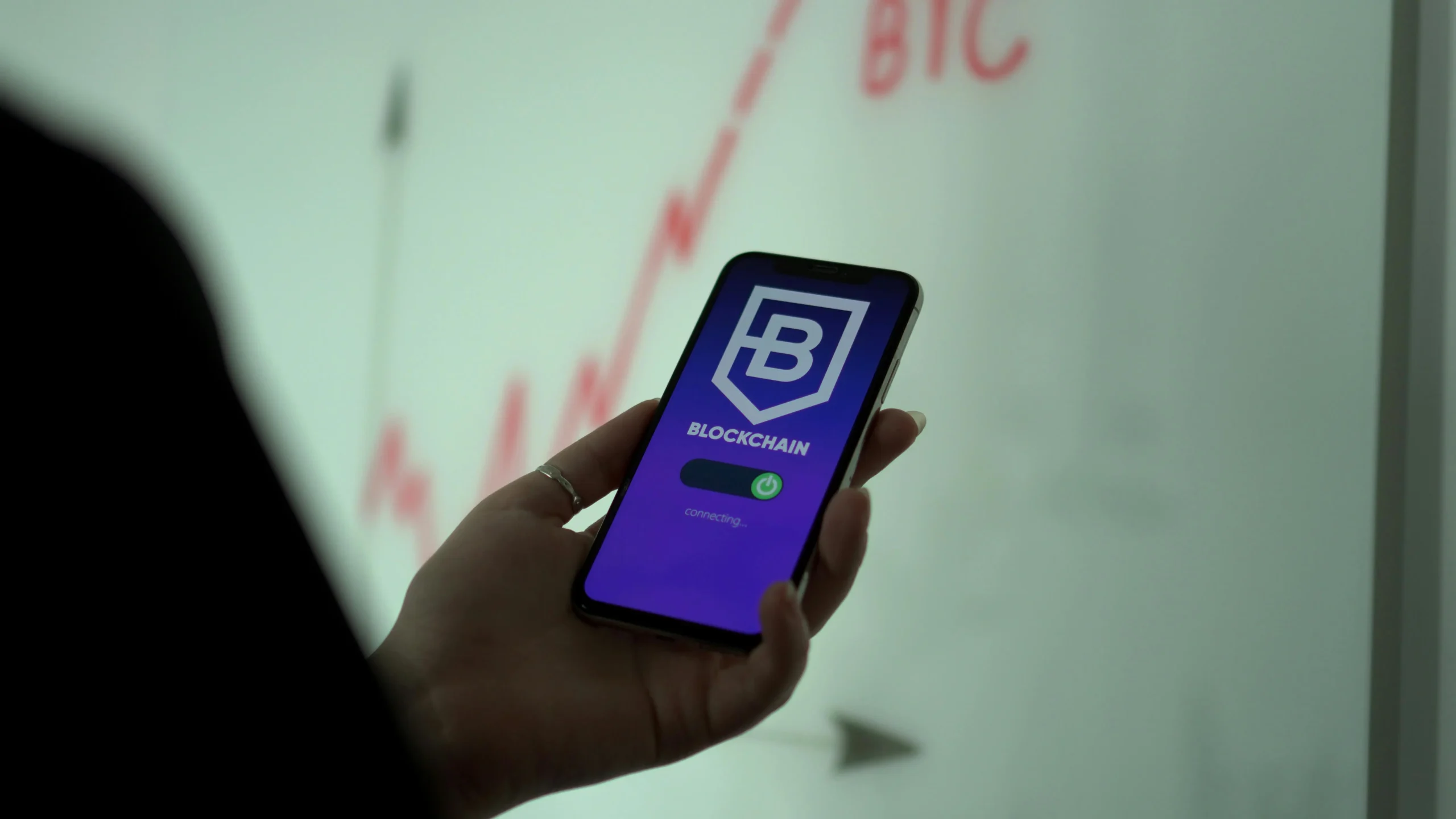 a mobile in the hands displaying what is blockchain technology